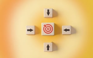 wooden blocks with arrows pointing at a target