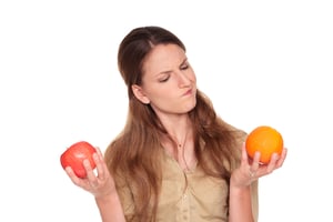 Woman comparing an apple to an orange