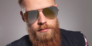 young man with a red beard wearing aviator sunglasses