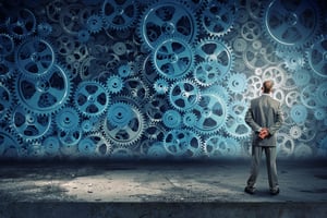 businessman standing in front of a wall of gears